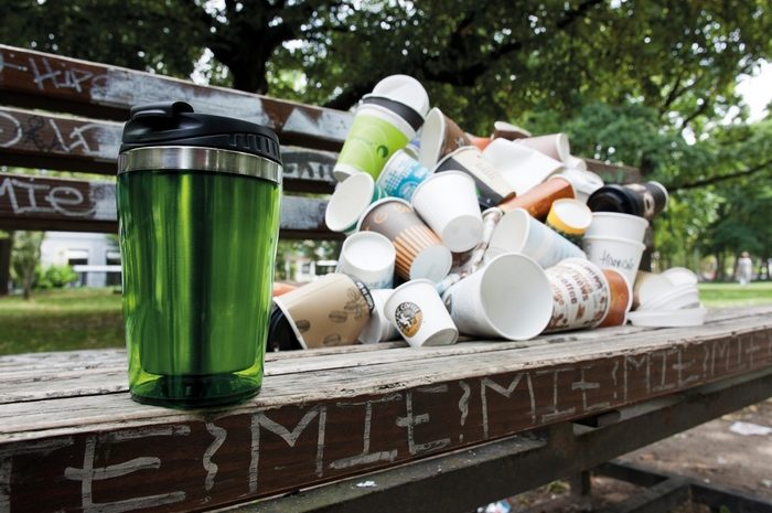 Coffee to go Becherhaufen auf Bank mit Mehrwegbecher